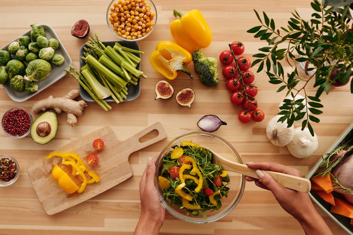 Fresh vegetables and salad ingredients on a kitchen table